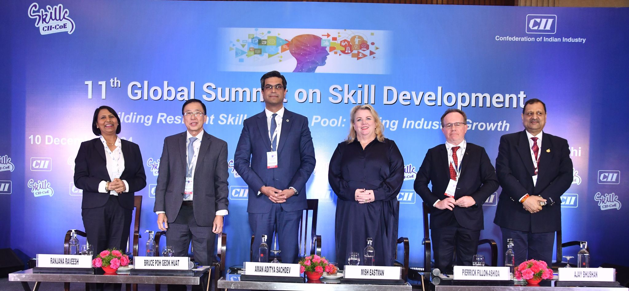 Panelists seated on stage at the 11th Global Summit on Skills with a blue backdrop.